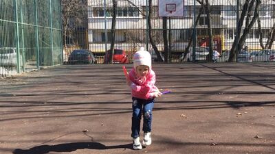 Четырехлетняя девочка прыгает со скакалкой